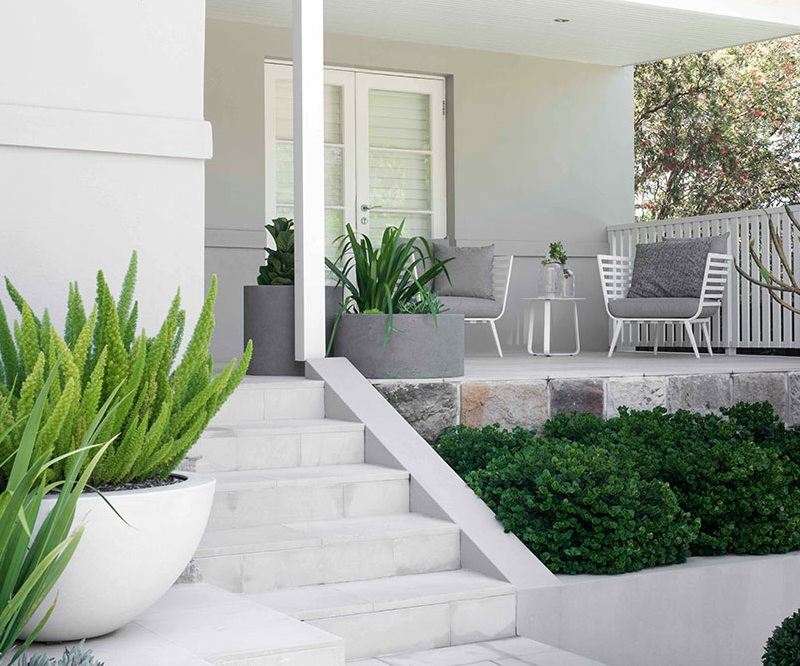 grande-jardiniere-béton-design-ovale-terrasse-chaises-blanches-coussins-gris grande jardinière