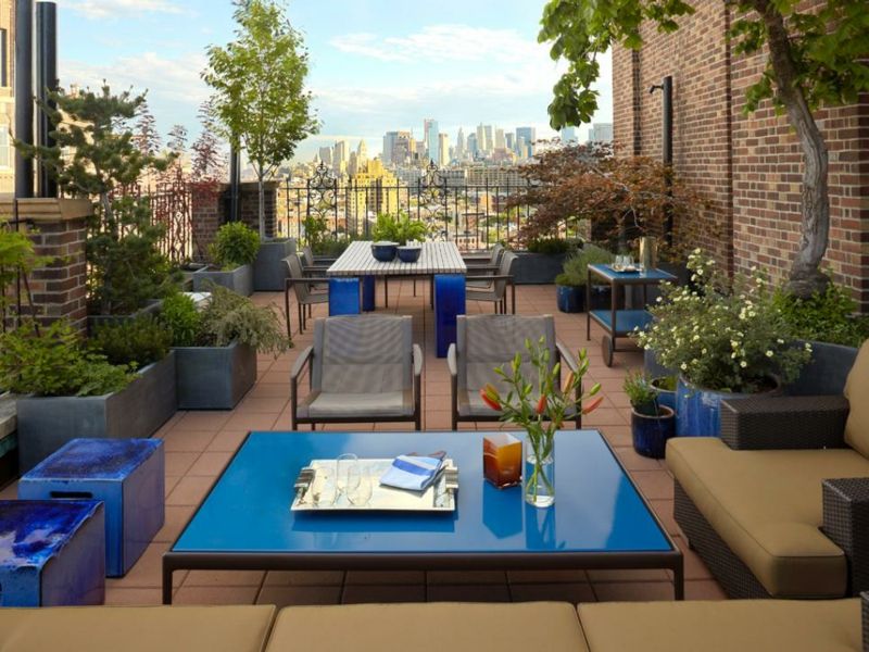 grande-jardiniere-béton-rectangulaire-ovale-bleue-terrasse-canapé-rotin-table-basse-bleue