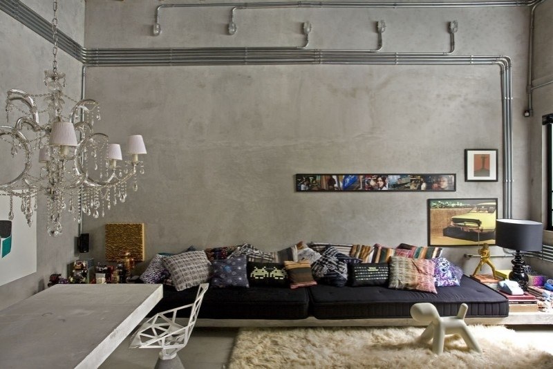 mobilier-beton-mur-béton-brut-lustre-cristal-canapé-bas-noir-coussins-décoratifs mobilier béton