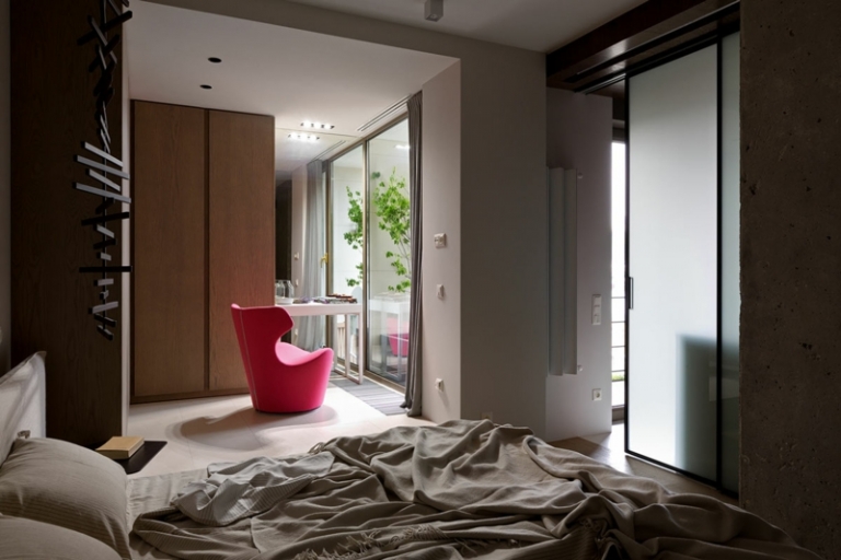 mur-beton-chambre-coucher-porte-coulissante-verre-fauteuil-rose