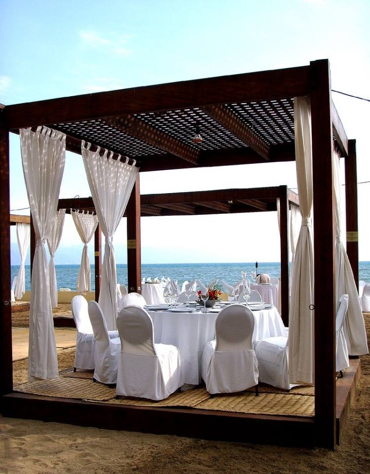 pergola-en-bois-rideaux-terrasse-sable-mer-table-ronde-chaises