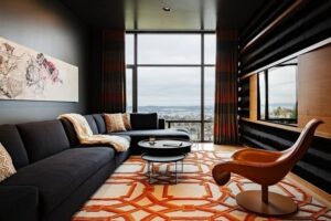 style-masculin-appartement-celibataire-canapé-gris-anthracite-tapis-beige-orange-fauteuil-cuir