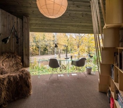 cabane-design-bureau-verre-asymétrique-lampe-poser-chaises-eames-fauteuil-housse-duveteuse