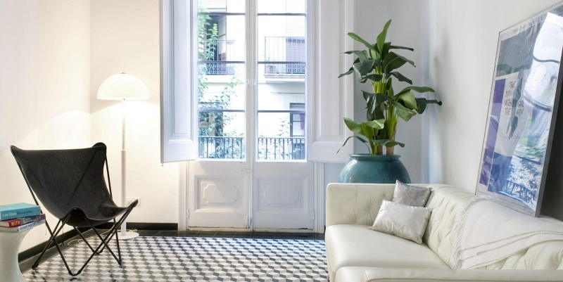 deco-salon-moderne-peinture-blanche-canapé-capitonné-blanc-chaise-noire-tapis-motif-géométrique-plante déco salon moderne
