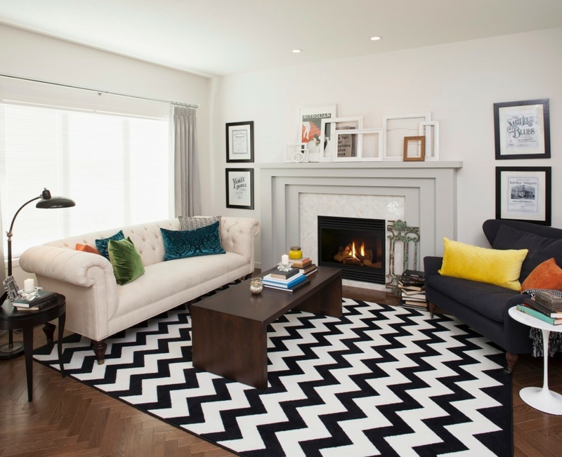 decoration-salon-tapis-noir-blanc-chevron-canapé-blanc-capitonné-fauteuil-noir-cheminée-classique
