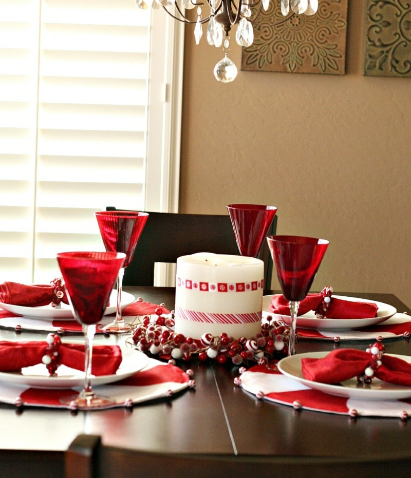 decoration-table-Noel-verres-rouges-serviettes-rouges-anneau-serviette-baies-décoratives-grande-bougie-cylindrique