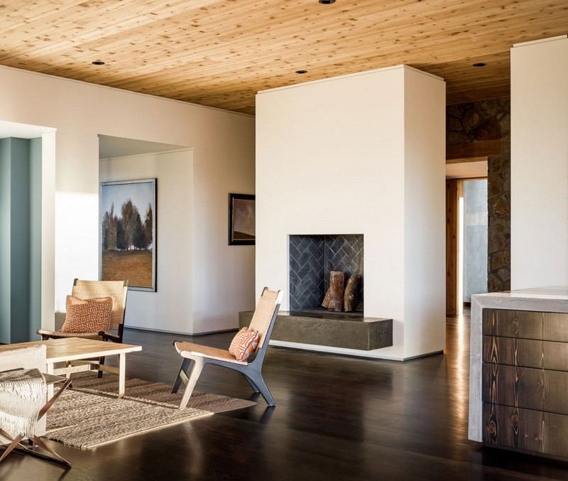 pierre-bois-maison-moderne-cheminée-bois-tapis-sisal-chaises-bois-table-basse pierre et bois