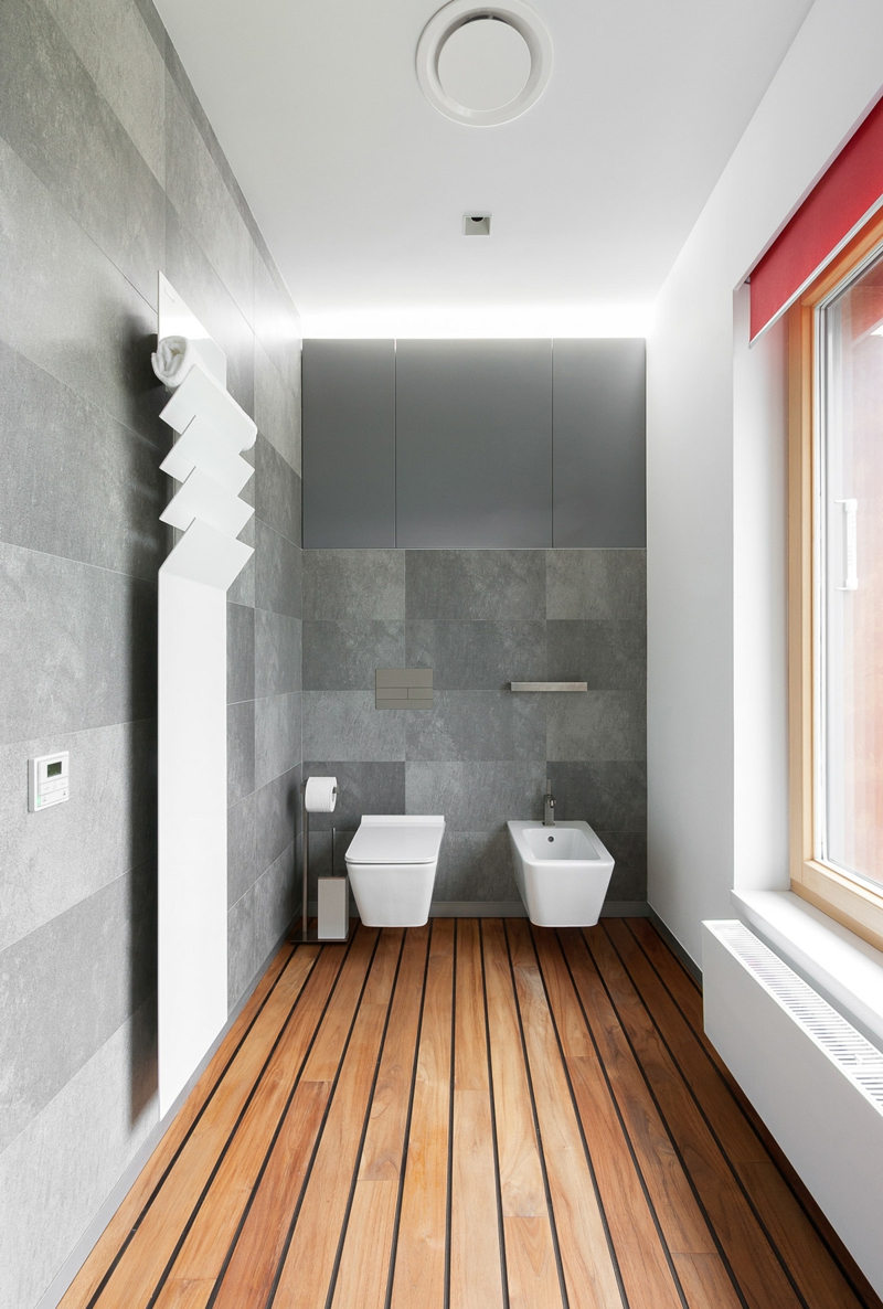 salle de bains avec carrelage mural aspect béton, plancher en bois et 