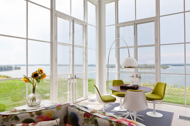 amenagement-veranda-moderne-baie-vitree-table-chaises-tulipe-blanc-vert-canape-bariole véranda moderne