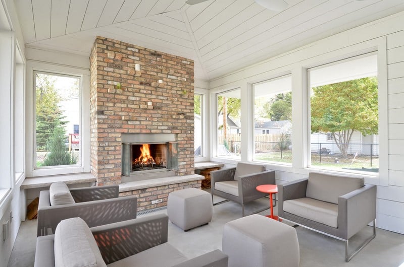 amenagement-veranda-moderne-cheminee-brique-meubles-gris véranda moderne