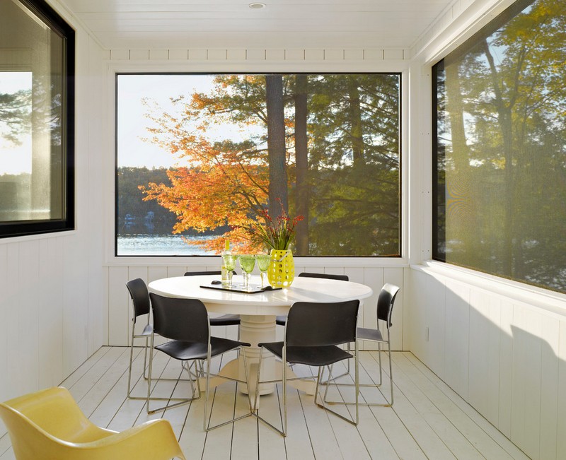 amenagement-veranda-moderne-grandes-fenetres-table-manger-ronde-chaises-noires véranda moderne