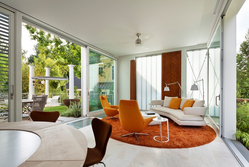 amenagement-veranda-moderne-porte-coulissante-canape-blanc-tapis-fauteuils-orange véranda moderne