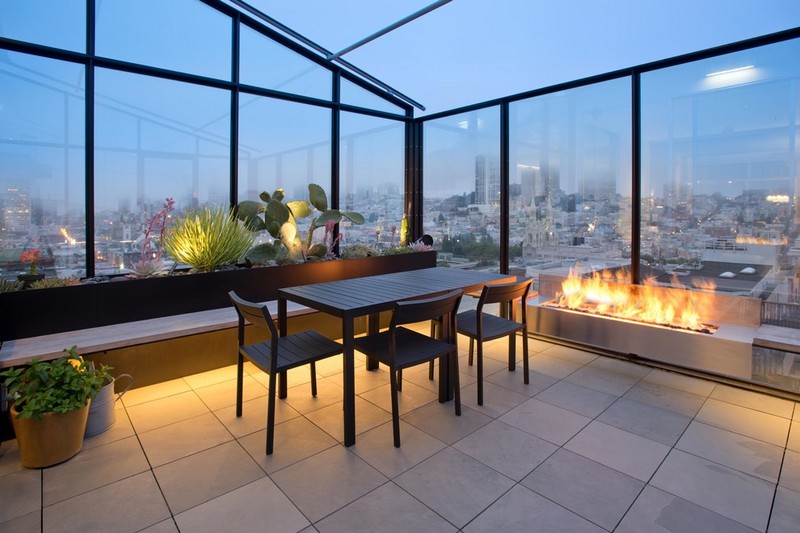 amenagement-veranda-moderne-vitree-cheminee-gaz-table-chaises-bois-plantes-vertes-toit-verre véranda moderne