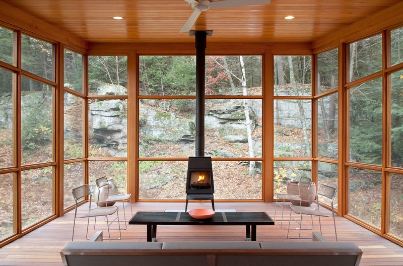 amenagement-veranda-moderne-vitree-poele-noir-chaises-metal-table-rectangle-bois
