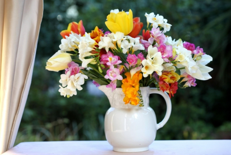 appui-fenetre-intérieur-décoré-bouquet-fleurs-printanières-broc-porcelaine