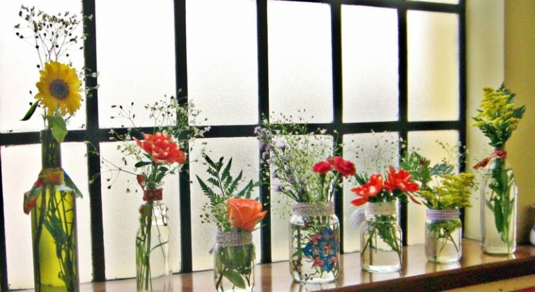 appui-fenetre-intérieur-décoré-fleurs-bouteilles-bocaux-dépareillés