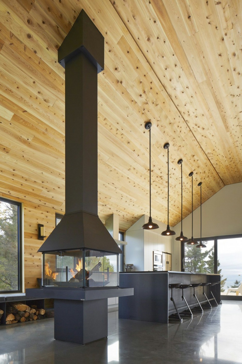 cheminée centrale métallique-noir-sol-grès-cérame-assorti-plafond-bois-clair
