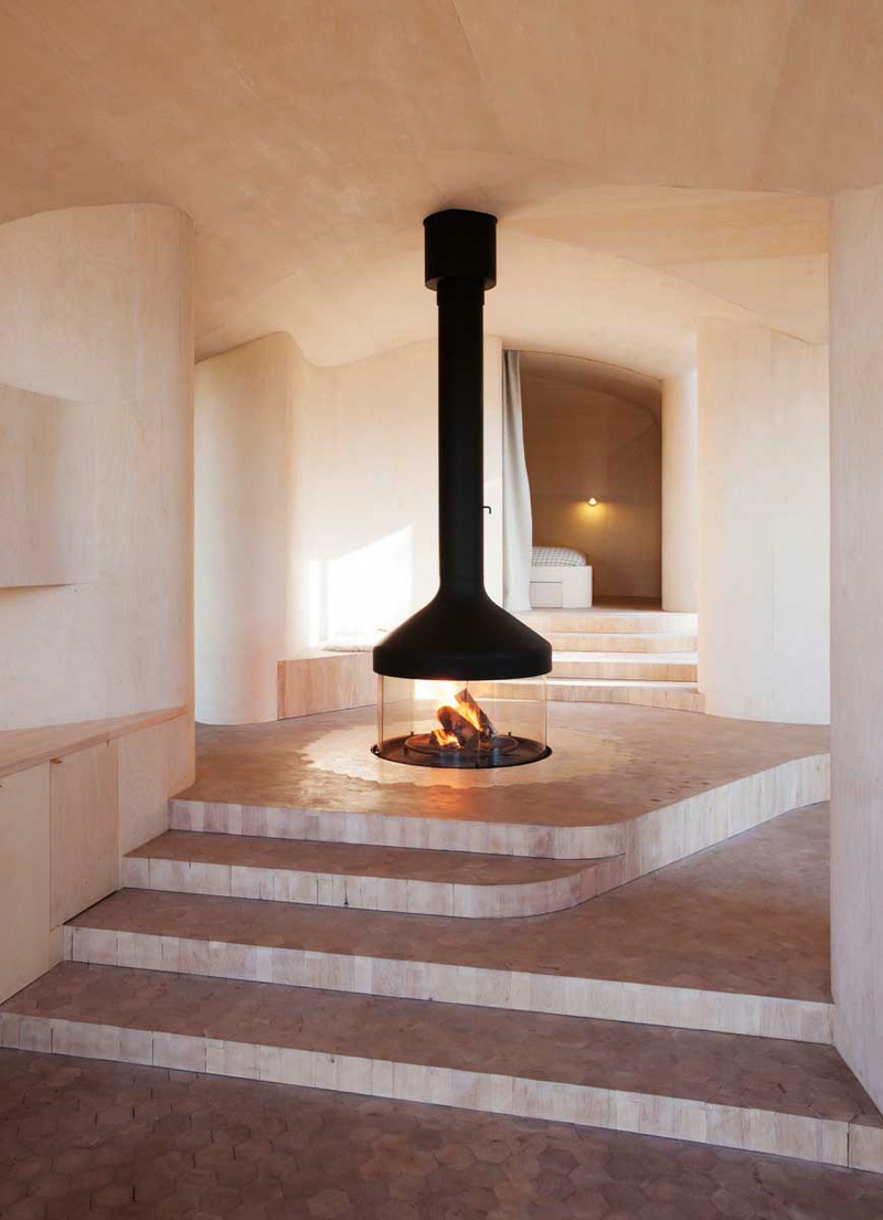 cheminée centrale noire-foyer-fermé-décor-minimaliste-murs-blancs-sol-carrelé