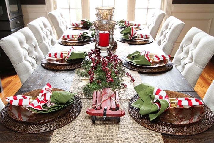 deco-table-noel-rouge-blanc-chemin-table-jute-arrangement-baies-rouges-branches-sapin-serviettes-vert-rouge