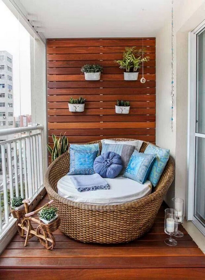 décoration-balcon-lit-jour-rond-coussins-bleus-sol-mur-bois