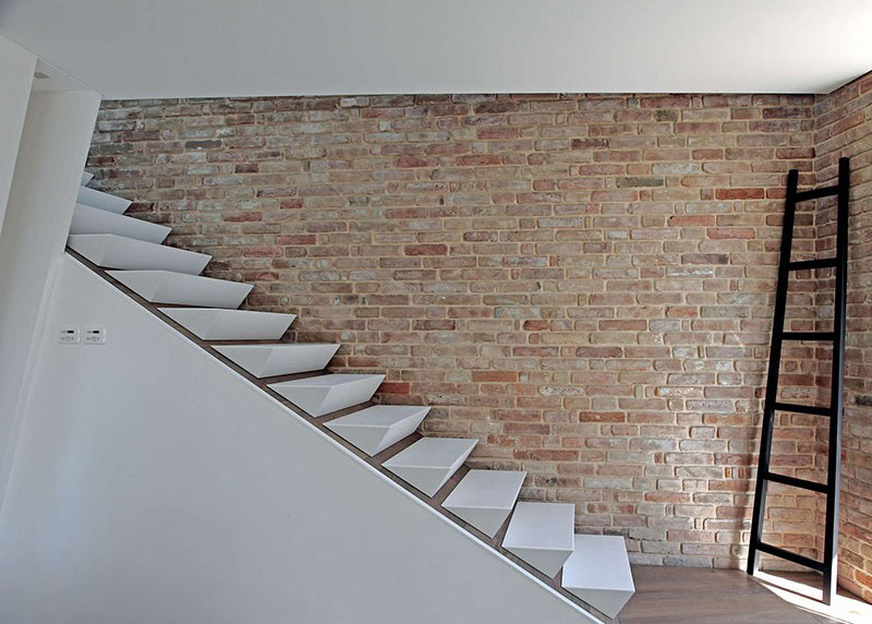 escalier sans rampe marches pyramidales mur brique 3ndy