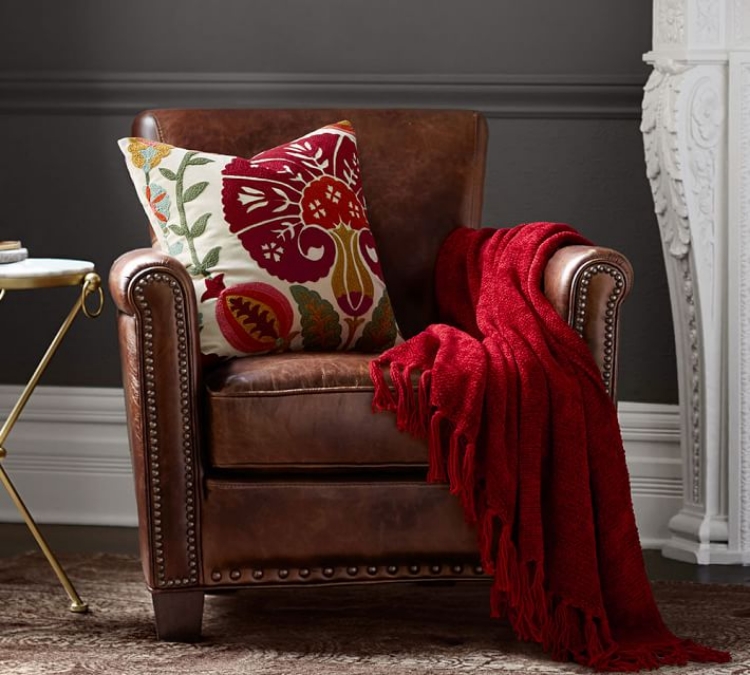 fauteuil-cuir-marron-rivets-metal-coussin-motif-floral-couverture-rouge fauteuil cuir marron