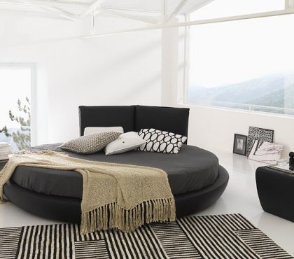 lit rond design noir-tapis-noir-blanc-coussins-assortis