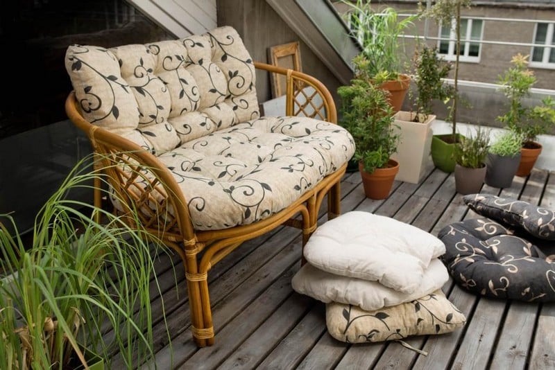 mobilier balcon canapé-rotin-clair-coussins-motifs-blancs-noirs