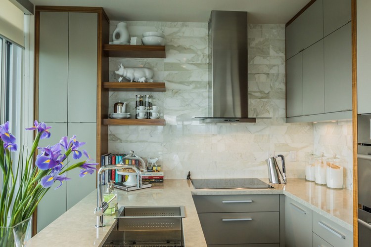 cuisine-u-ouverte-avec-ilot-évier-armoires-grises-murs-carrelés-marbre