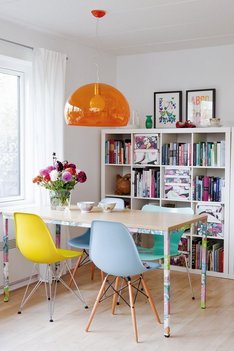 idee-deco-salle-manger-meuble-rangement-livres-multicolores-suspension-orange-chaises-eames-jaune-bleu