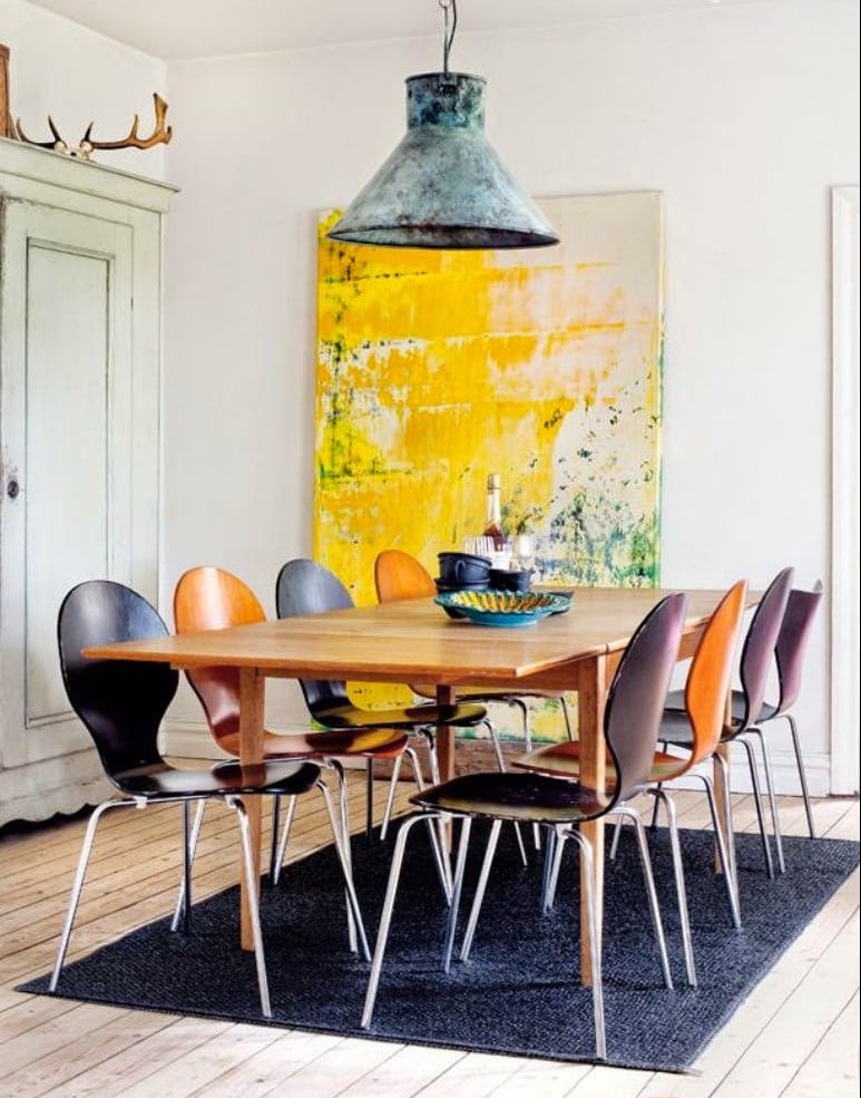 idee-deco-salle-manger-tableau-jaune-chaises-orange-noir-tapis-noir idée déco salle à manger