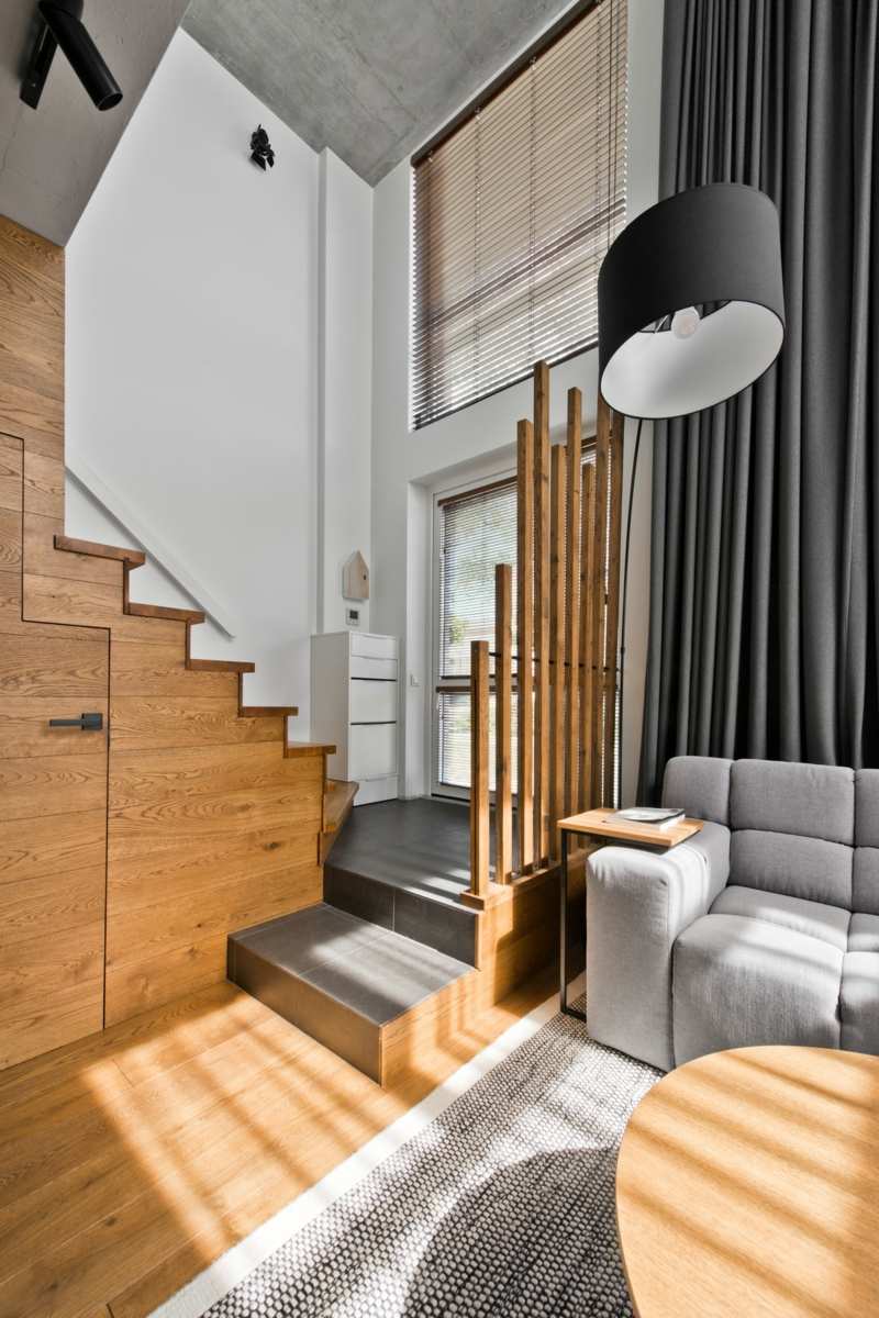 mobilier-scandinave-entrée-escalier-bois-rideaux-taupe-lampadaire