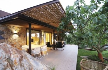 pergola-adossee-osier-terrasse-bois-composite-facade-pierre-naturelle-meubles-jardin-noir-blanc-figuier