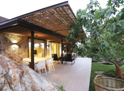 pergola-adossee-osier-terrasse-bois-composite-facade-pierre-naturelle-meubles-jardin-noir-blanc-figuier