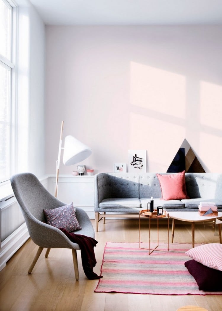 salon scandinave -canape-droit-gris-bois-tapis-rayures-roses-fauteuil-gris-table-cuivre