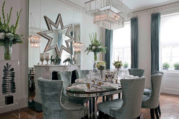 style Art déco salle-manger-table-ovale-fauteuils-gris-rivetes-miroir-etoile-lustre-pampilles 