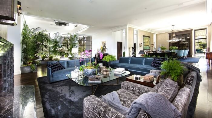 style Art déco salon-canapes-bleus-tapis-noir-motif-losanges-noir-blanc-plantes-vertes 