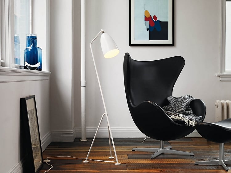 fauteuil-Oeuf-Jacobsen-cuir-noir-pied-central-métallique-repose-pieds-assorti