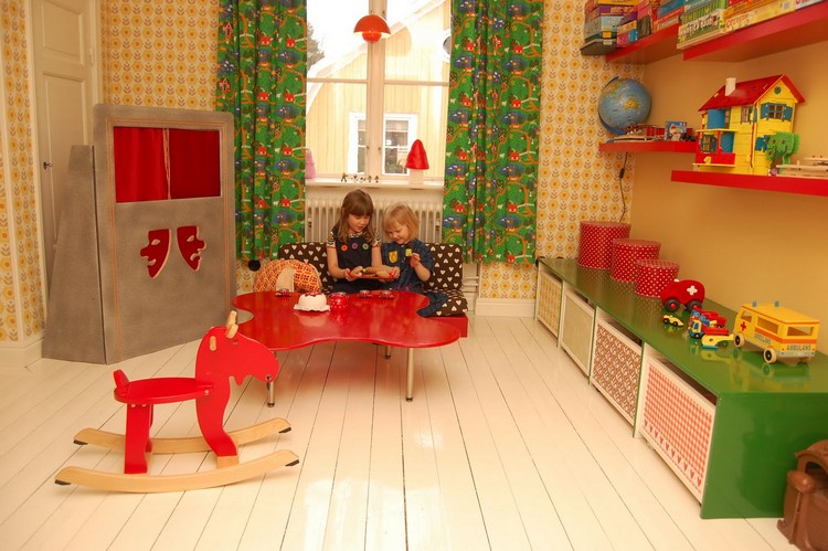 salle de jeux enfant cheval-bascule-table-basse-rouge-etageres-rouges-boites-rangement-rideaux-dessins