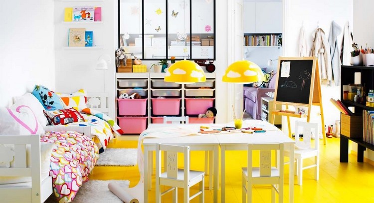 salle de jeux enfant lits-meuble-rangement-boites-roses-table-chaises-chevalet-peinture-ardoise