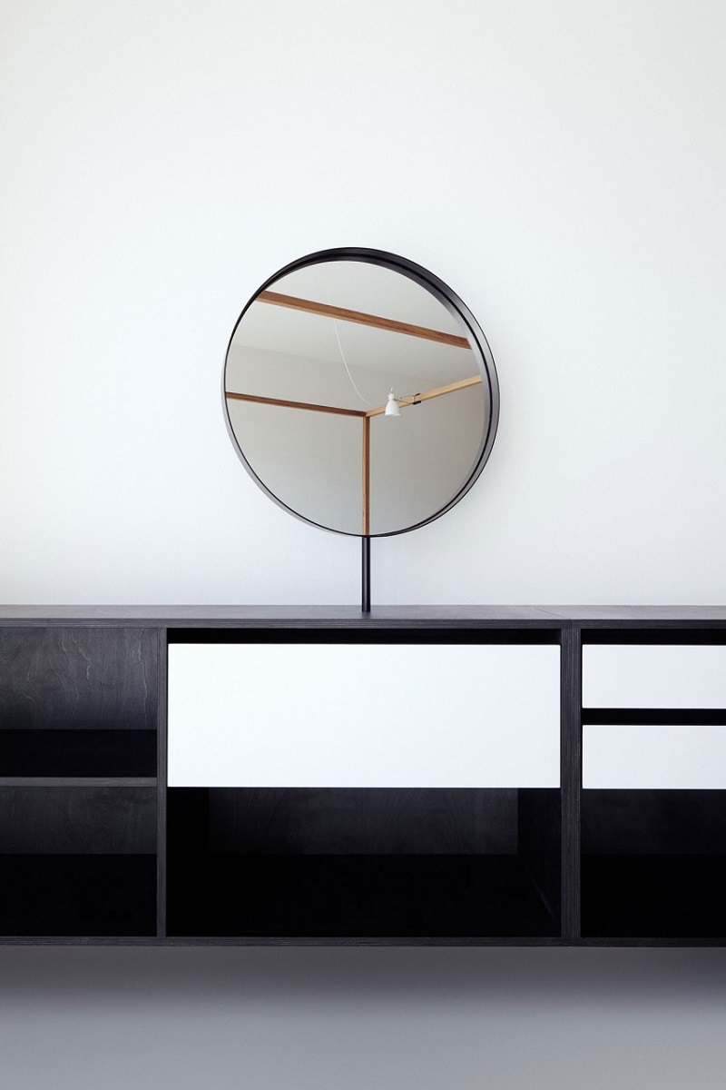 aménagement studio minimaliste miroir rond meuble noir blanc