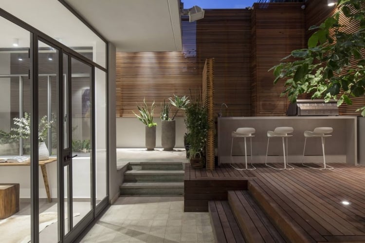 brise-vue en bois –terrasse-bar-beton-chaises-bar-blanches-plantes-vertes