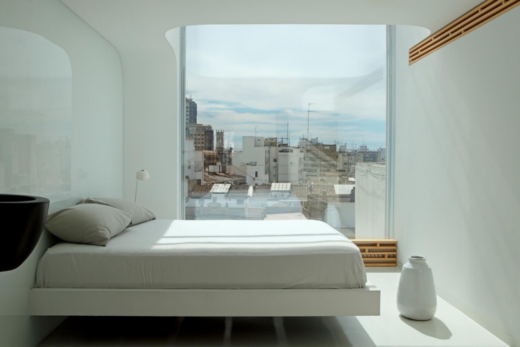 chambre-blanche-lit-suspendu-minimaliste-accents-bois-fenêtre-panoramique