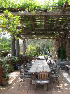 coin repas -pergola-bois-vignes-grimpantes-table-chaises-bois-carrelage-terre-cuite
