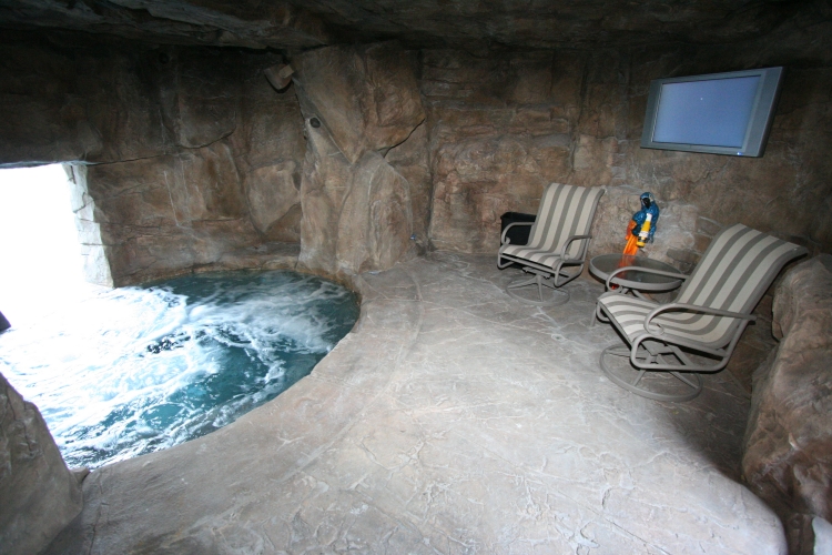 grande-piscine-grotte-murs-sol-pierre-fauteuils-design