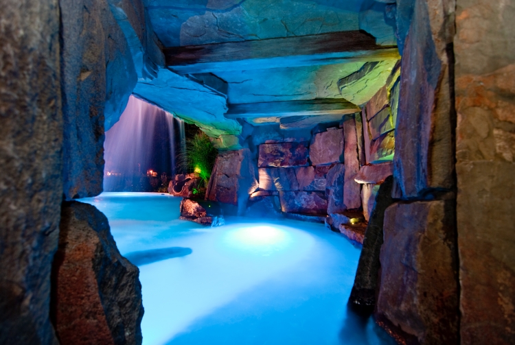grande piscine lagon-grotte-éclairage-bleu-pierres-naturelles