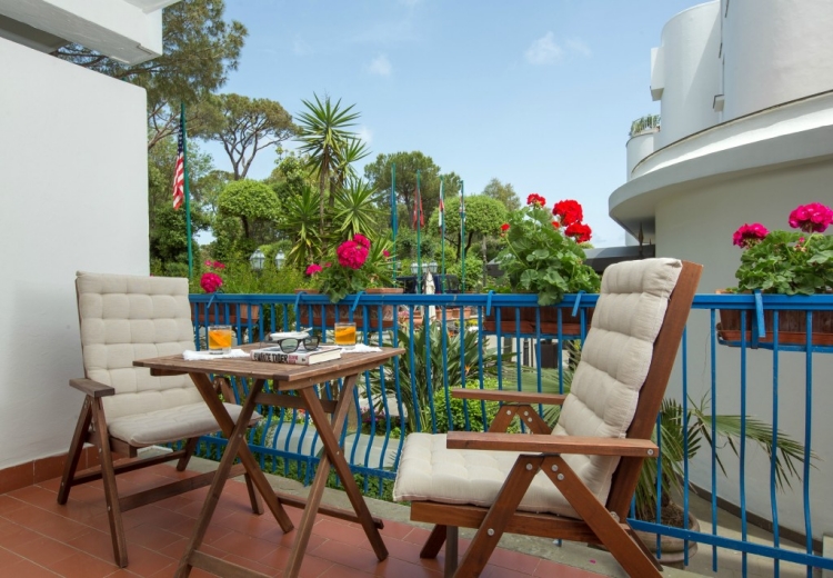jardin-balcon-géraniums-rouges-roses-meubles-teck
