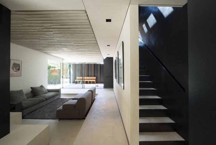 salon-canapes-gris-tapis-gris-plafond-bois-escalier-droit-peinture-noire