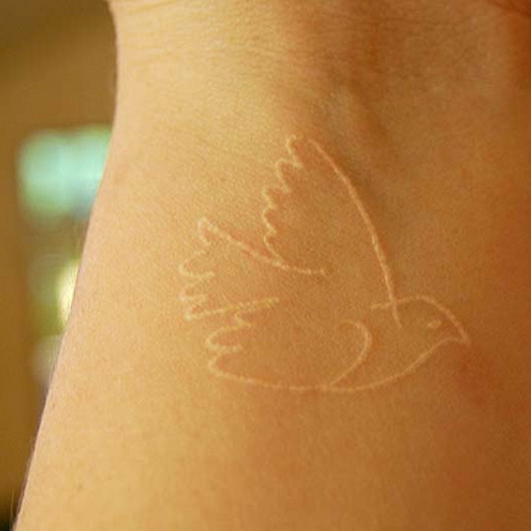 tatouage encre blanche femme poignet -oiseau vol tendre