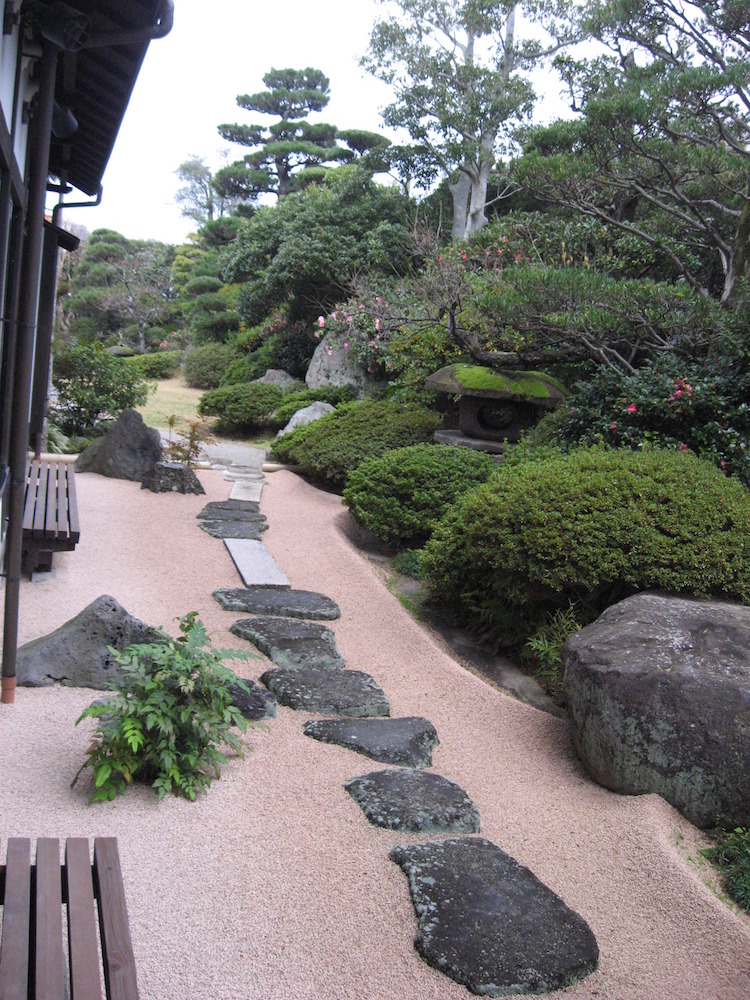 aménagement jardin en pente -japonais-gravier-décoratif-arbustes-taillés-allée-pierre-naturelle